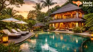 Luxury Bali villa with tropical garden, private pool, and lounge chairs during a warm sunset evening.