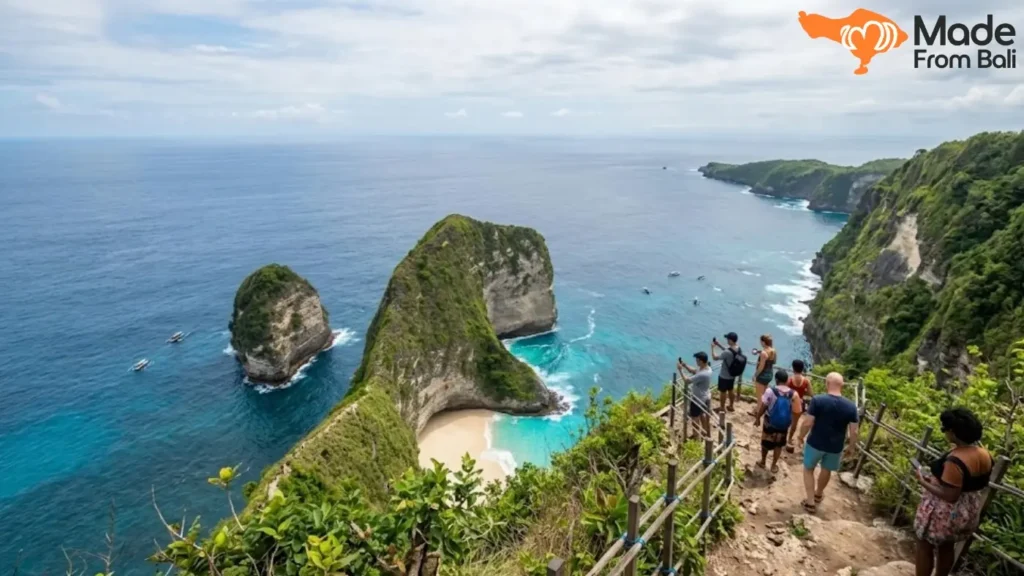 Tourists standing at Kelingking Beach viewpoint during a West Nusa Penida tour with ocean cliff views.