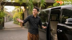 A Bali private driver opens a car door, showing the pickup service travelers can book for day trips.