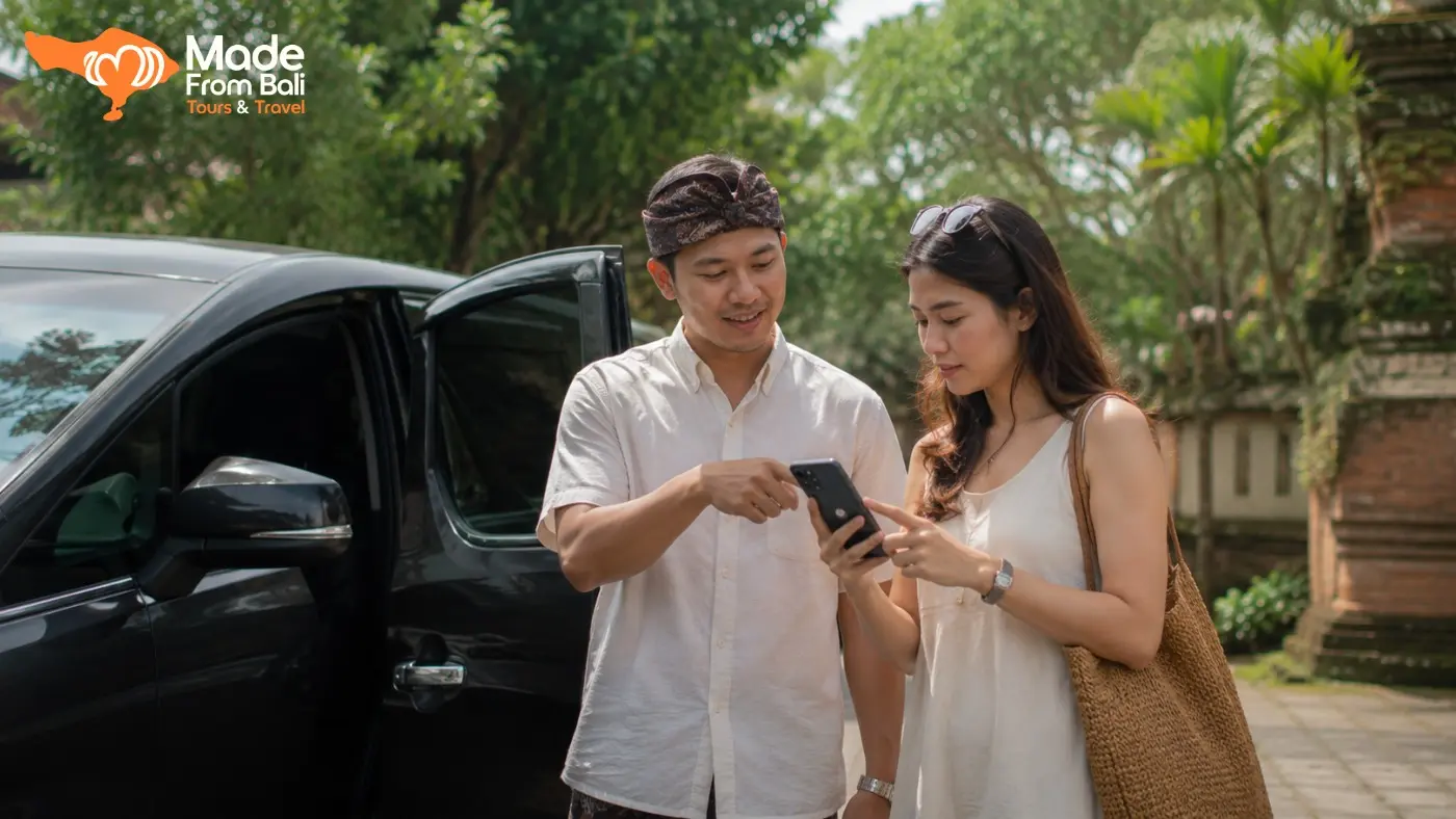 Wisatawan memeriksa informasi di ponsel bersama driver Bali sebelum memulai perjalanan dengan mobil pribadi.