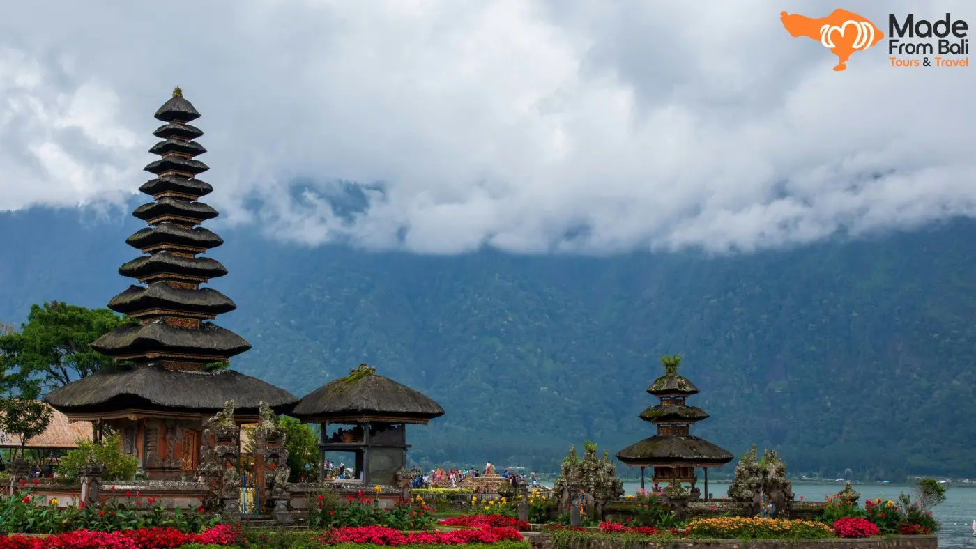 Pura Ulun Danu Bratan berdiri di tepi Danau Beratan dengan latar pegunungan dan awan tebal.