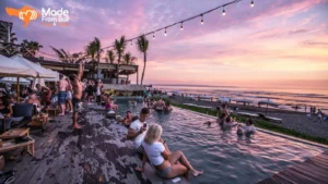 Guests relax in a beach club pool overlooking the ocean during sunset, showing Bali’s social beach club atmosphere