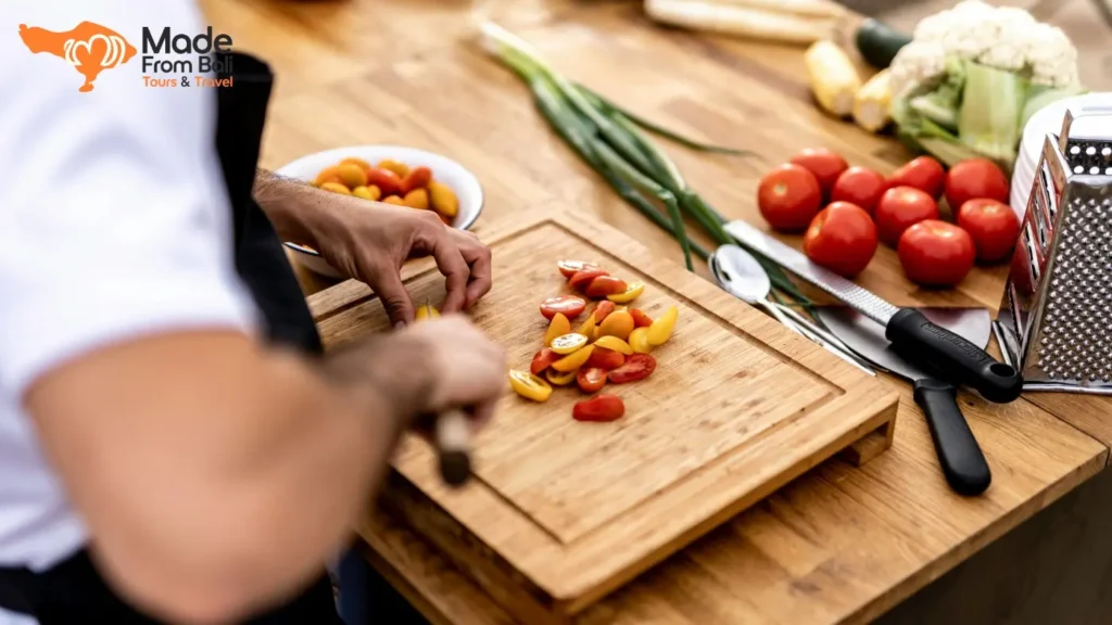 A chef prepares fresh vegetables during a Bali cooking class before guests start making local dishes
