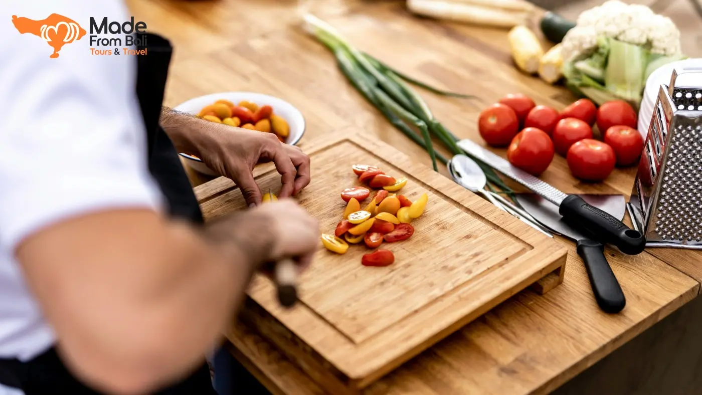 A chef prepares fresh vegetables during a Bali cooking class before guests start making local dishes
