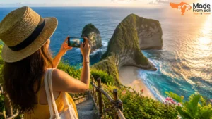 Wisatawan memotret pemandangan tebing dan laut Bali saat matahari terbenam untuk mendapatkan foto terbaik.